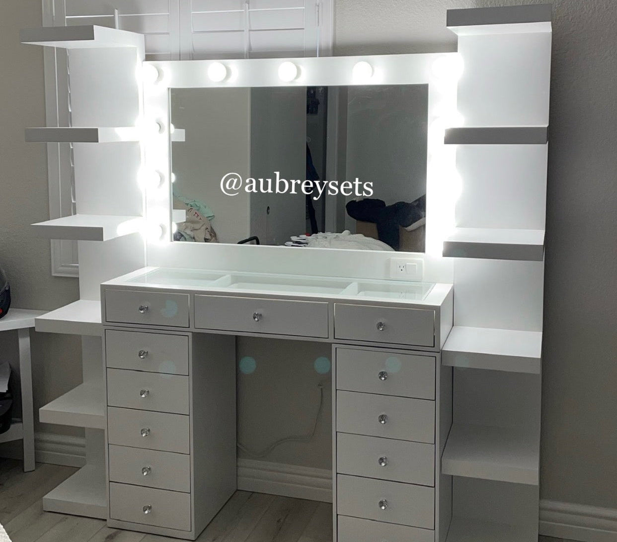 White vanity with mirror and lights in a room setting